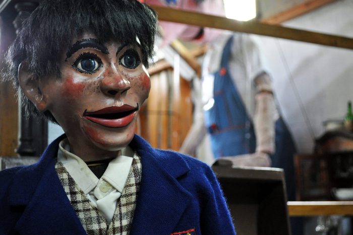 Creepy old puppet dummie of a boy in school suit