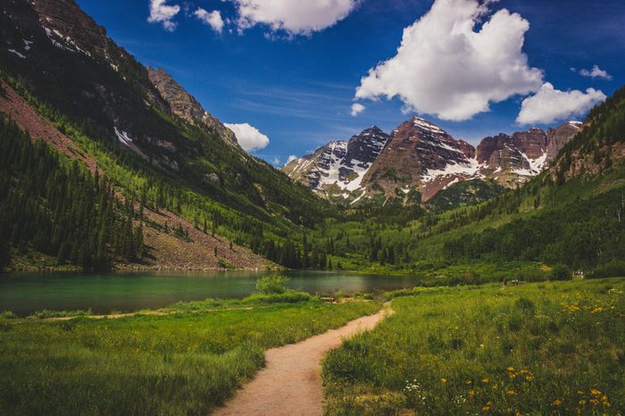 Stunning Maroon Bells peaks and trail leading to Maroon Lake in summer near Aspen, Colorado