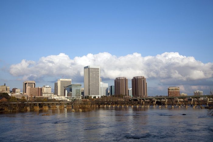 Richmond, Virginia cityscape skyline with blue sky and clouds on the James River.