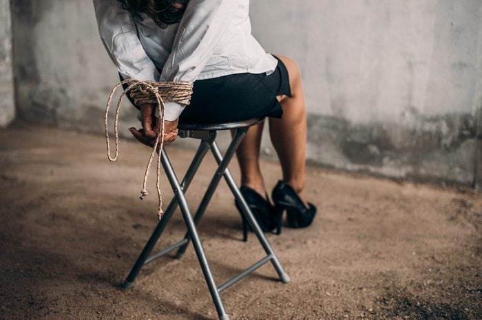 woman hands bound. Women were handcuffed and Sitting on a chair.woman tied hand to a chair.Crime Concept.Criminality Concept.Bonded business.