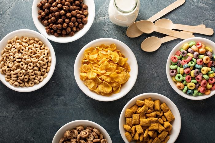 Variety of cold cereals in white bowls, quick breakfast for kids overhead shot