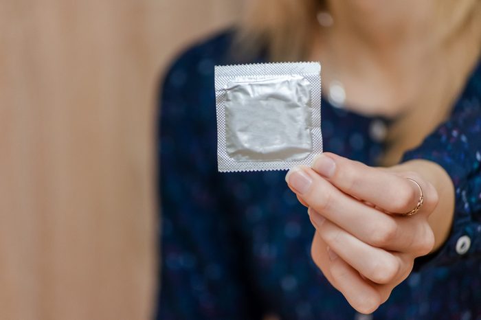 Condom ready to use in female hand, give condom safe sex concept. Prevent infection and Contraceptives control the birth rate or safe prophylactic.