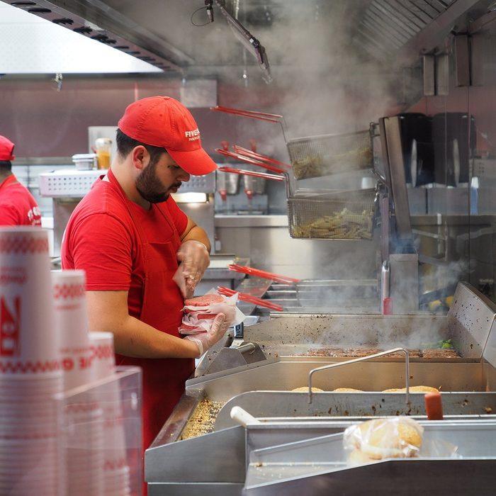 Closeup of crews working at Five Guys burger chain busily, Avenue des Champs