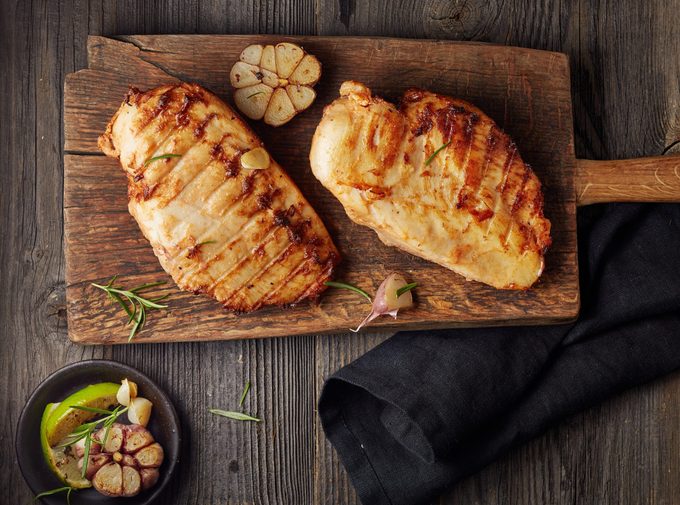 Grilled chicken fillet on wooden cutting board