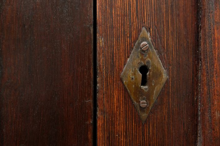 Keyhole in old wooden door, copy space on one side.