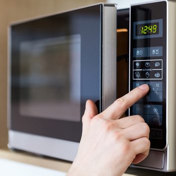 Detail of male hand while using the microwave