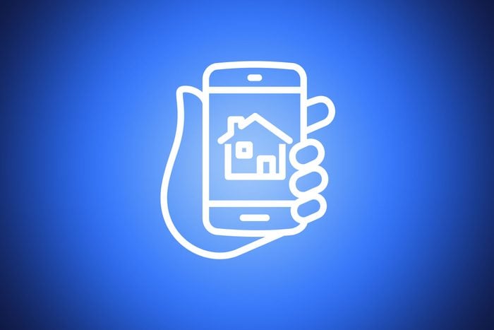 icon of hand holding a smartphone showing a house on blue background