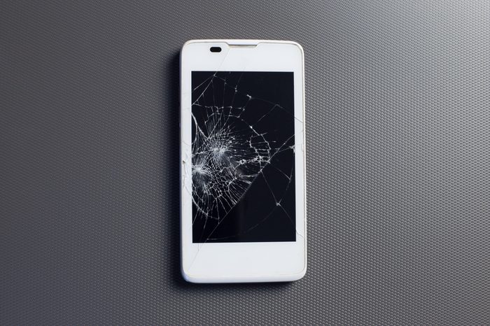 broken phone, modern touch screen smartphone with broken screen, on gray background.