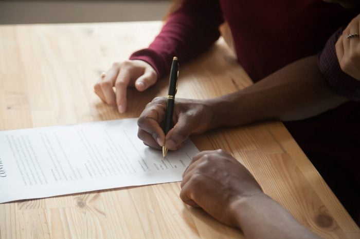 African american man signing contract, black man hand putting signature on official document, biracial clients customers couple make purchase or sign prenuptial agreement concept, close up view