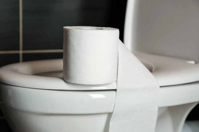 Roll of paper on toilet bowl in restroom