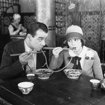 Couple sharing a noodle in a restaurant
