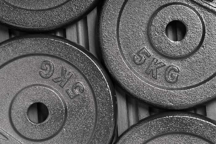 Weight plates on a black rubber floor inside a weight training gym / fitness studio
