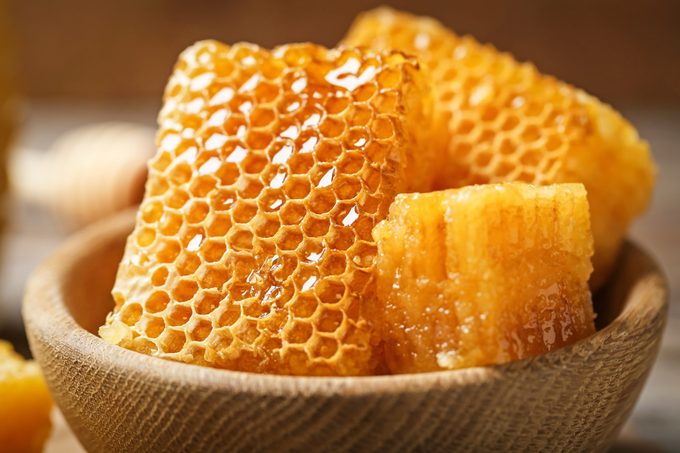 Fresh honeycombs in wooden bowl, closeup