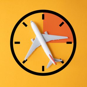 model toy airplane over a blank clock shape with a part of the clock darkened to indicate a limited or ideal time to book tickets