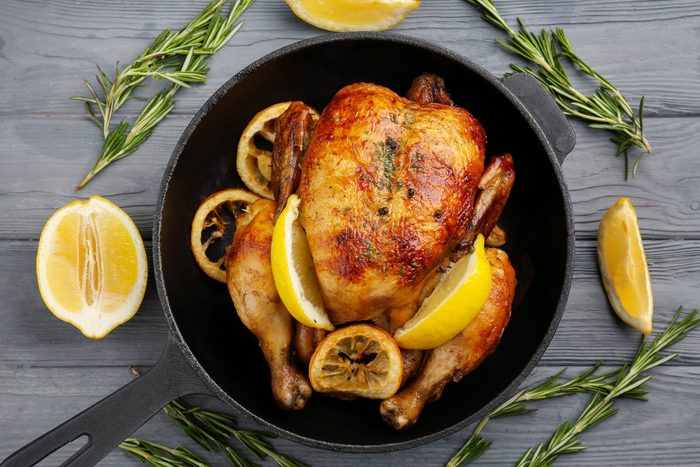 Homemade baked chicken with lemon on wooden background