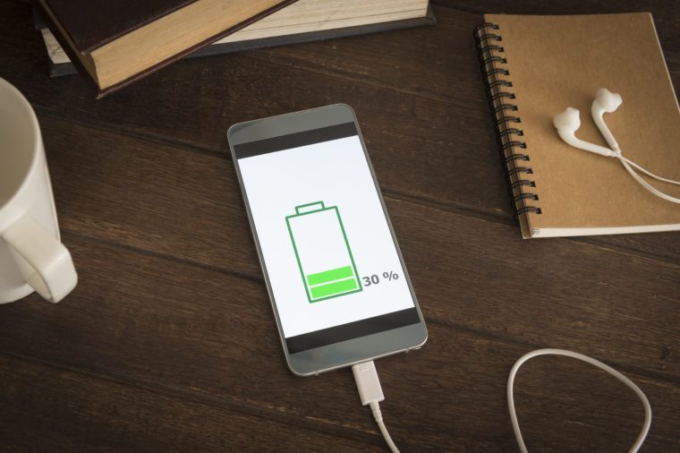 Mobile smart phones charging on wooden desk