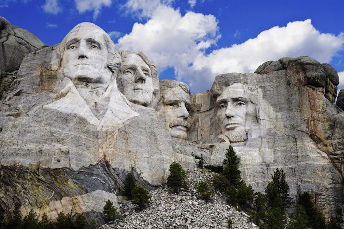 Mt. Rushmore National Memorial Park in South Dakota with bright blue sky in background. Sculptures of former U.S. presidents; George Washington,Thomas Jefferson,Theodore Roosevelt and Abraham Lincoln.