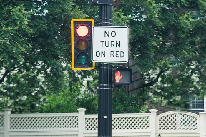 No Turn On Red Sign attached next to a traffic light pole made in rectangular shape paint in white and black color