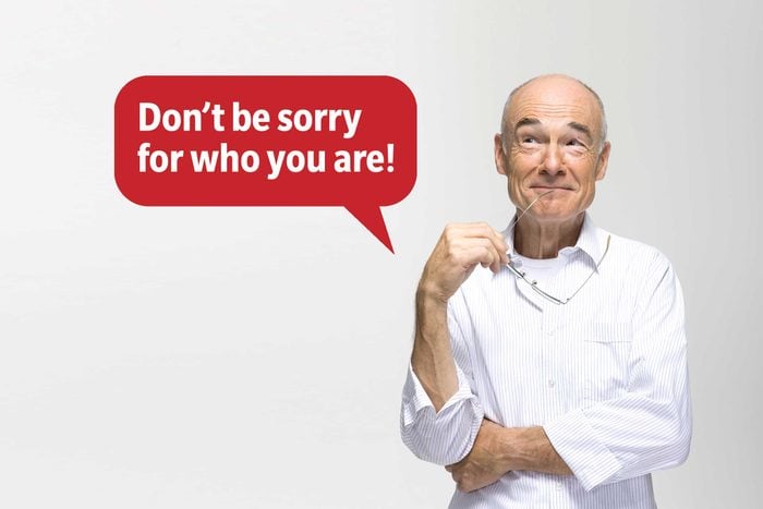 Smiling man looking up delivering a comeback roast, speech bubble text: "Don't be sorry for who you are!"