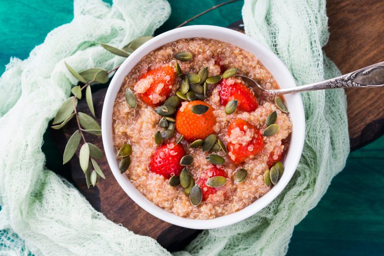 Quinoa porridge with strawberries and pumpkin seeds in bowl. Light dairy and gluten free breakfast