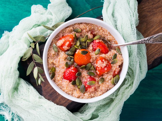 Quinoa porridge with strawberries and pumpkin seeds in bowl. Light dairy and gluten free breakfast