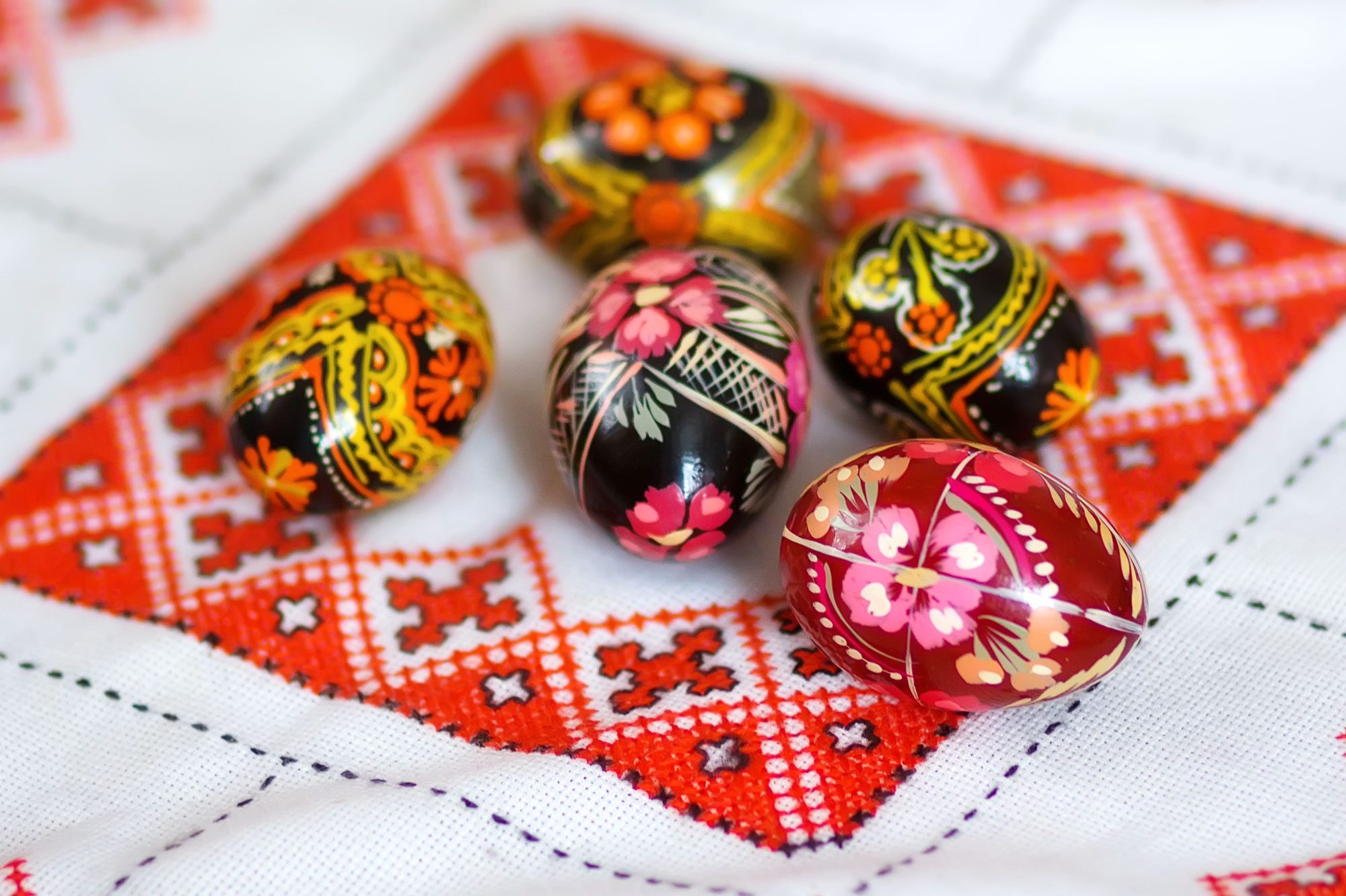 Mix Of Colored Easter Eggs With The Traditional Ukrainian Slavic Designs. Beautiful Pysanka Handmade Ukrainian Traditional On A Traditional Embroidered Tablecloth Vyshyvanka. Selective Focus