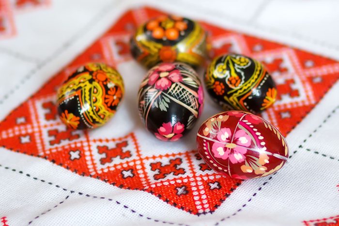 Mix Of Colored Easter Eggs With The Traditional Ukrainian Slavic Designs. Beautiful Pysanka Handmade Ukrainian Traditional On A Traditional Embroidered Tablecloth Vyshyvanka. Selective Focus