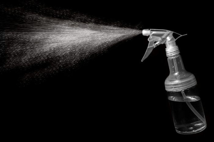 The mist spray bottle to spray water into the air, against a black background.