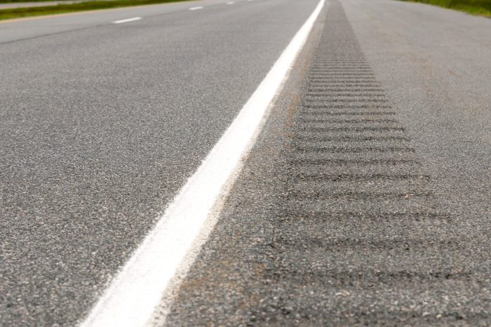 The rumble strip on the side of a highway, The strip consists of shallow pits in the paved shoulder that vibrate a vehicle if it crosses the line onto the shoulder.