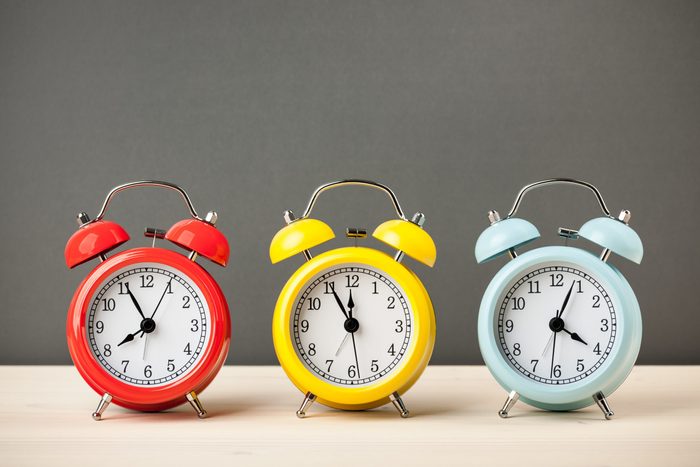 Three colorful alarm clocks on desktop