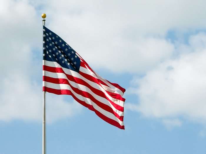 USA flag waving with a cloudy blue sky