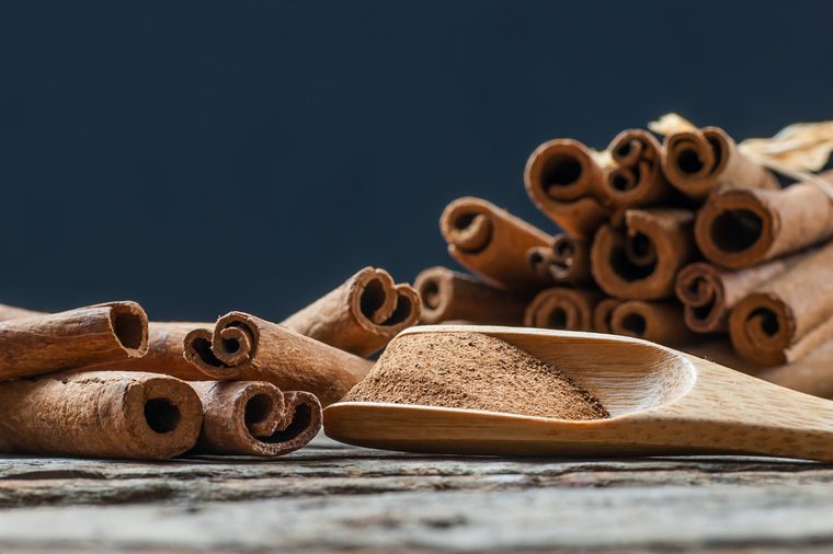 Close up cinnamon sticks and cinnamon powder in wooden spoon 