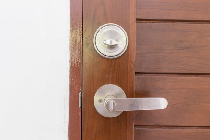 Modern stainless knob dead lock on teak wooden door, Interior object