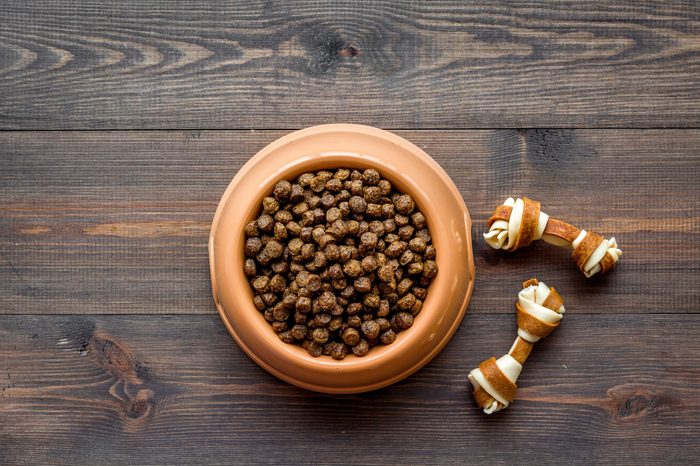 large bowl of pet - dog food on wooden background top view mockup