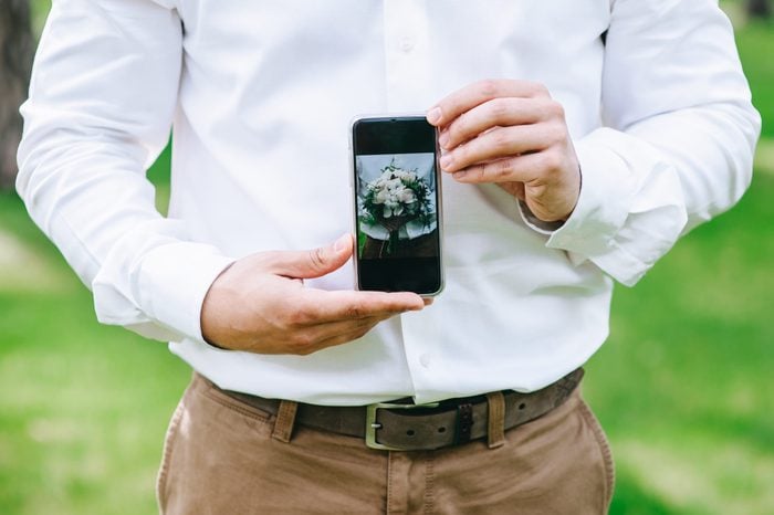 photo wedding bouquet on the phone in the hands of groom