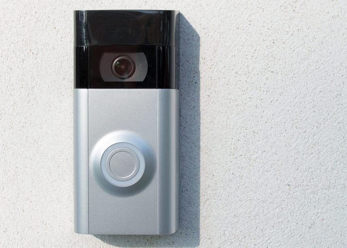 Ring Intercom outdoors on white plastered wall with call and camera, copy space. Close up