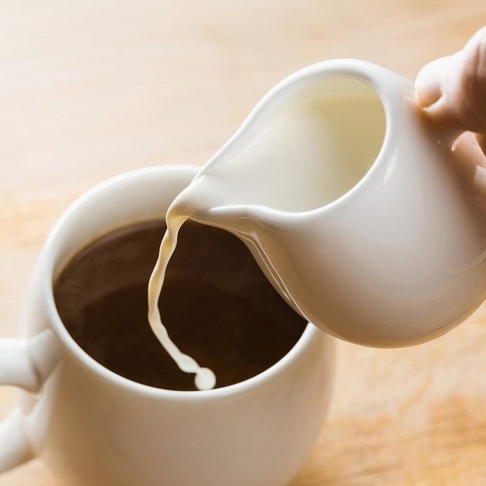 Closeup Pouring Cream into Cup of Hot Coffee.; Shutterstock ID 571084270; Job (TFH, TOH, RD, BNB, CWM, CM): TOH