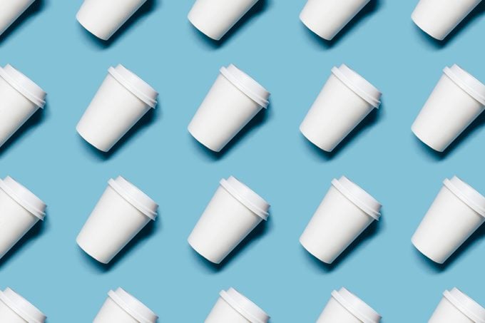 Pattern with lot of paper cups for coffee or tea on blue background.