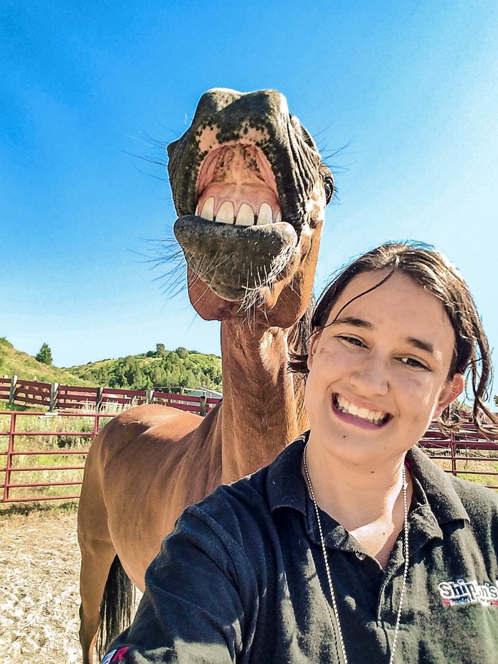 horse smiles for a selfie with woman