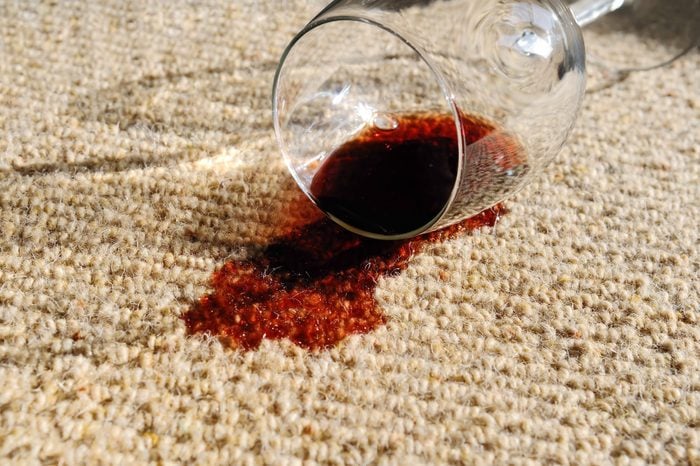 A glass of red wine, spilt on a pure wool carpet.
