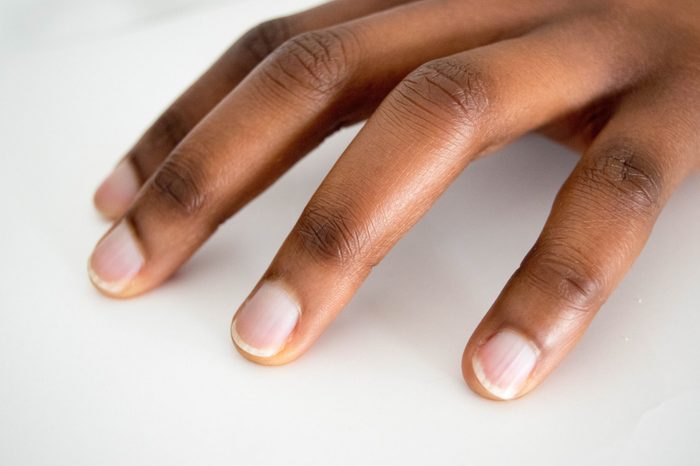 African American Dark brown skin Woman hand with french manicure isolated on white background. Close-up. Untouched.