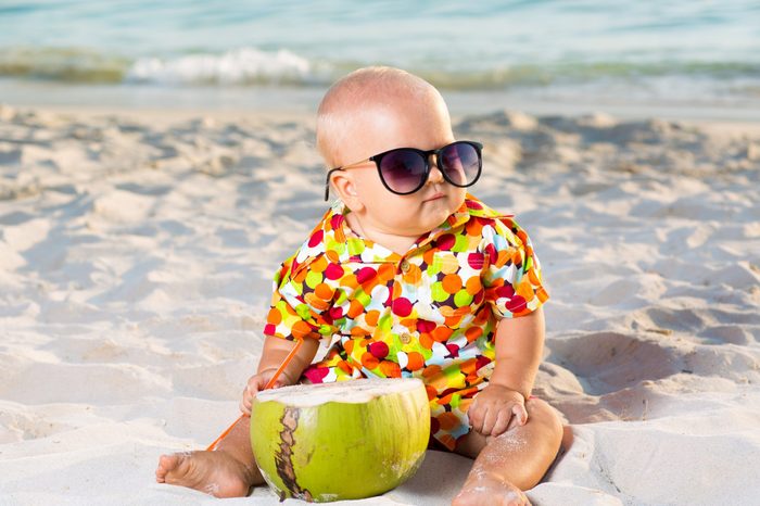 Funny baby wearing sunglasses with coconut