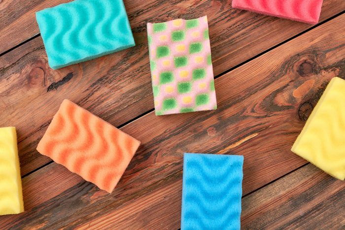 Group of multicolored kitchen sponges. Set of colorful sponges for kitchen on wooden background. Housekeeping and cleaning concept.