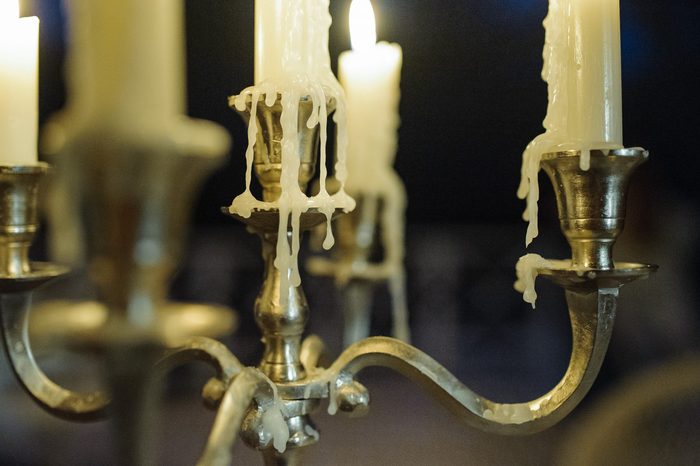 Metal candlestick with burning candles and melting wax