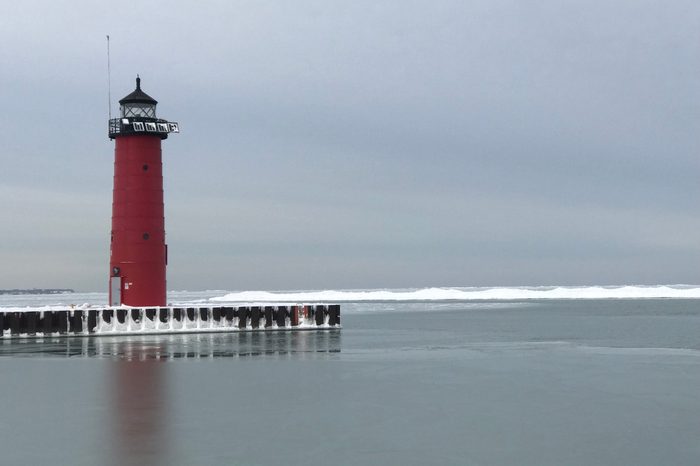 Red lighthouse on blue cloud sky in winter at Michigan Lake in Kenosha, Wisconsin, USA.