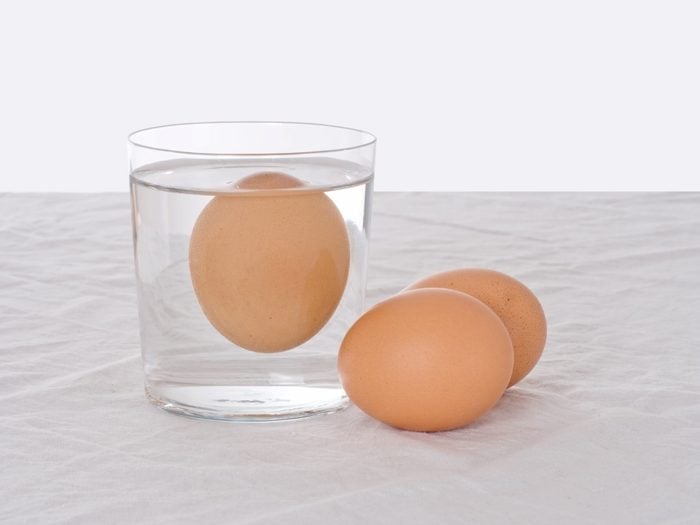 Rotten egg, salmonella risk. Old fashioned test. Bad egg floats in glass of water.