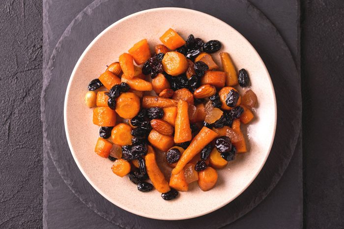 Traditional Jewish Tzimmes dessert with carrot, raisins and dried fruits on table. Top view. Israeli cuisine