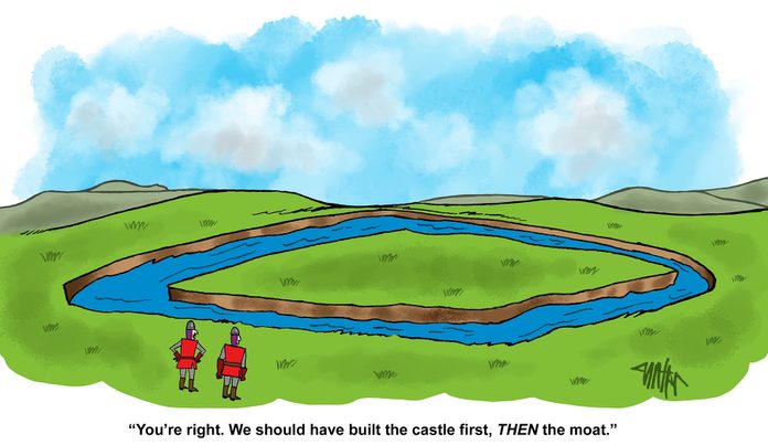 two knights discuss how they should have built the caste first as they stare at a field with a moat creating an island within