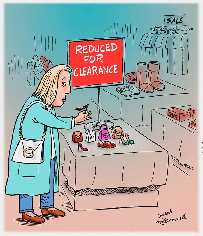 in a store, a woman looks at miniature objects on a table labeled "reduced for clearance"