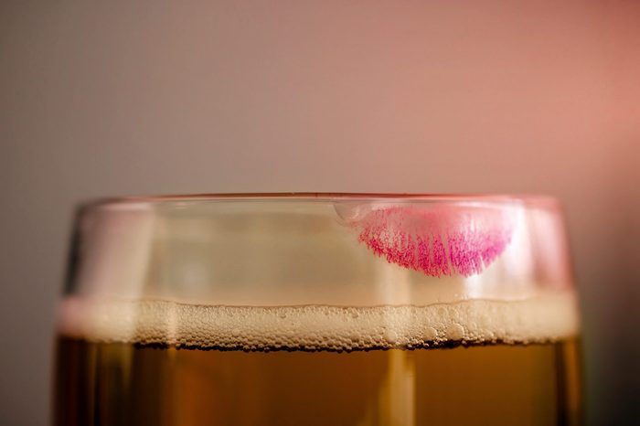 Woman Drinking Beer Concept. Closeup of Glass of Beer with Red Lipstick Mark. Feminine Mood